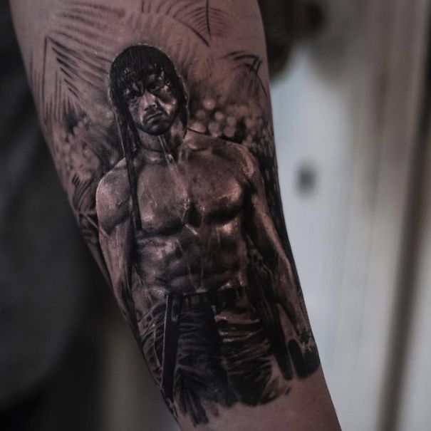 Realistic tattoo on arm by Belgian tattooist, depicting a detailed figure with a muscular build.