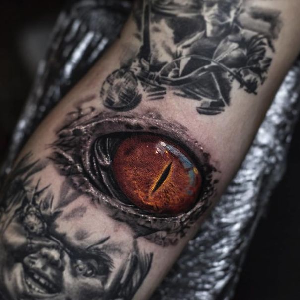 Realistic tattoo by Belgian artist featuring a vivid eye design that seems printed on the skin.