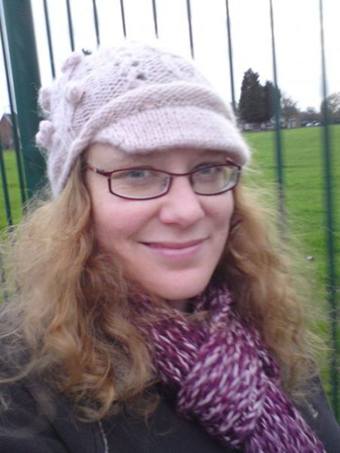 Smiling woman in a knitted hat and scarf outdoors, representing diverse depression symptoms.