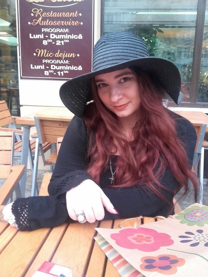 A woman with long hair and a black hat sits at an outdoor cafe, illustrating that depression symptoms have no face.