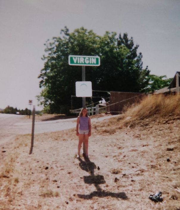 a 12 years old girl standing under the "Virgin" sign 