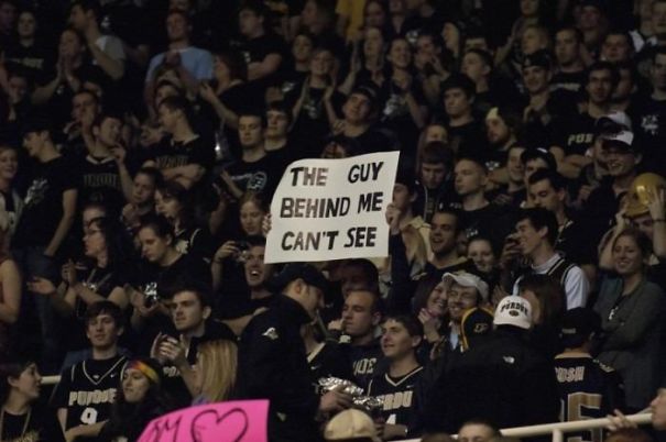 man holding a sign so that people behind him couldn't see anything 