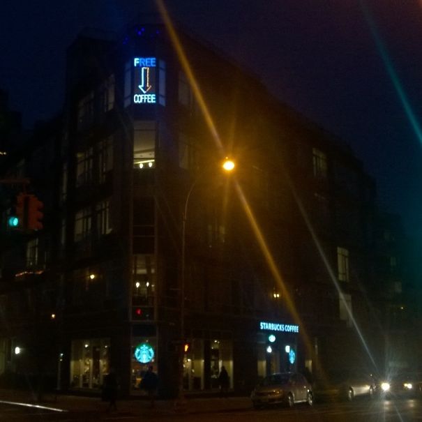 sign that says "free coffee" pointing at Starbucks 