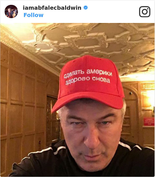 Alec Baldwin wearing red baseball cap 