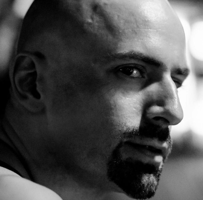 Black and white portrait of a serious-looking, bald man with facial hair, illustrating that depression symptoms have no face.