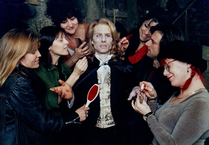 Behind the scenes of Interview With The Vampire movie with makeup artists applying details on the vampire actor’s face.
