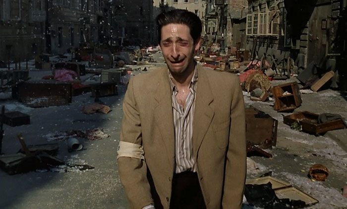Scene from The Pianist movie showing a distressed man in a destroyed urban setting for fun facts about movies.