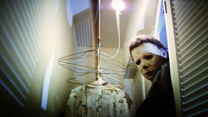 Michael Myers lurking in a dimly lit closet scene from Halloween movie, highlighting fun facts about movies.