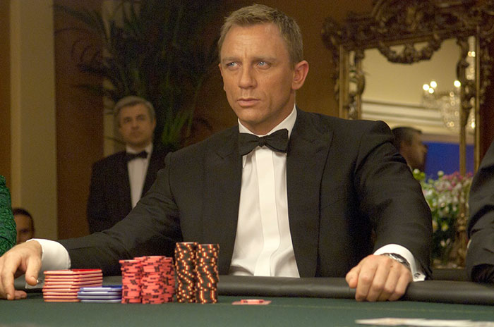 James Bond in Casino Royale movie scene, dressed in tuxedo playing poker, featured in fun facts about movies.