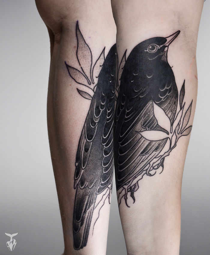 Nature and Art Nouveau inspired tattoo of a detailed bird with leaves on a person's forearm.