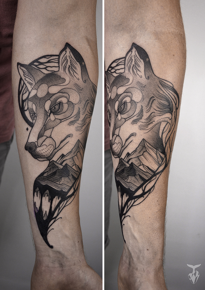 Nature and Art Nouveau inspired tattoo featuring a wolf and mountain design on a person's forearm.