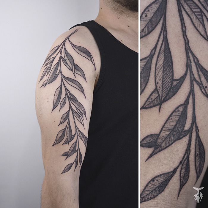 Nature-inspired tattoo with Art Nouveau leaf design on upper arm.