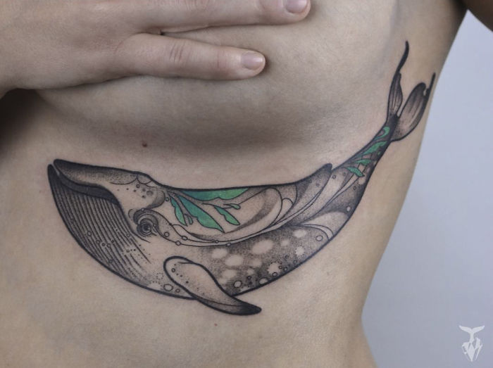 Nature and Art Nouveau inspired whale tattoo with green and black details on ribcage.