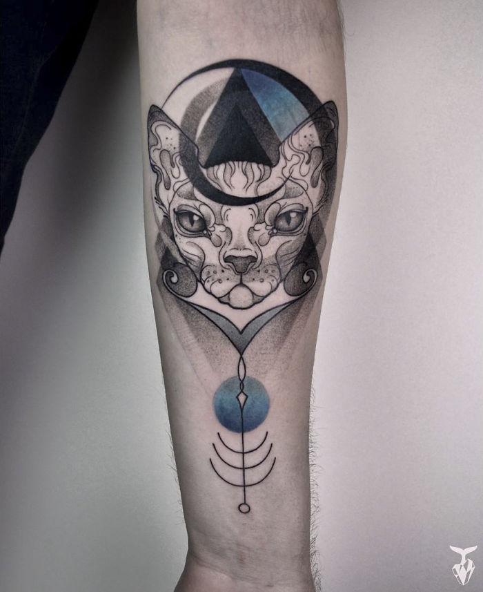 Nature and Art Nouveau inspired tattoo of a cat on a forearm with geometric and artistic elements.