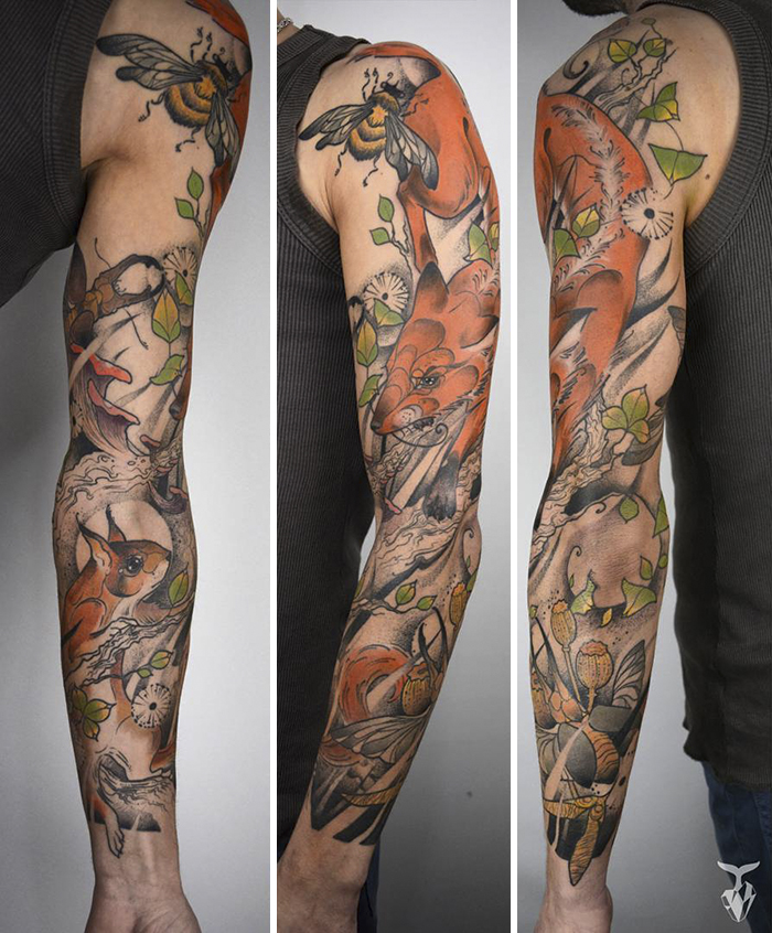 Arm adorned with nature and Art Nouveau inspired tattoos featuring leaves and animals.