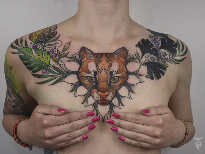 Chest tattoo featuring a nature-inspired Art Nouveau design with a tiger and foliage.