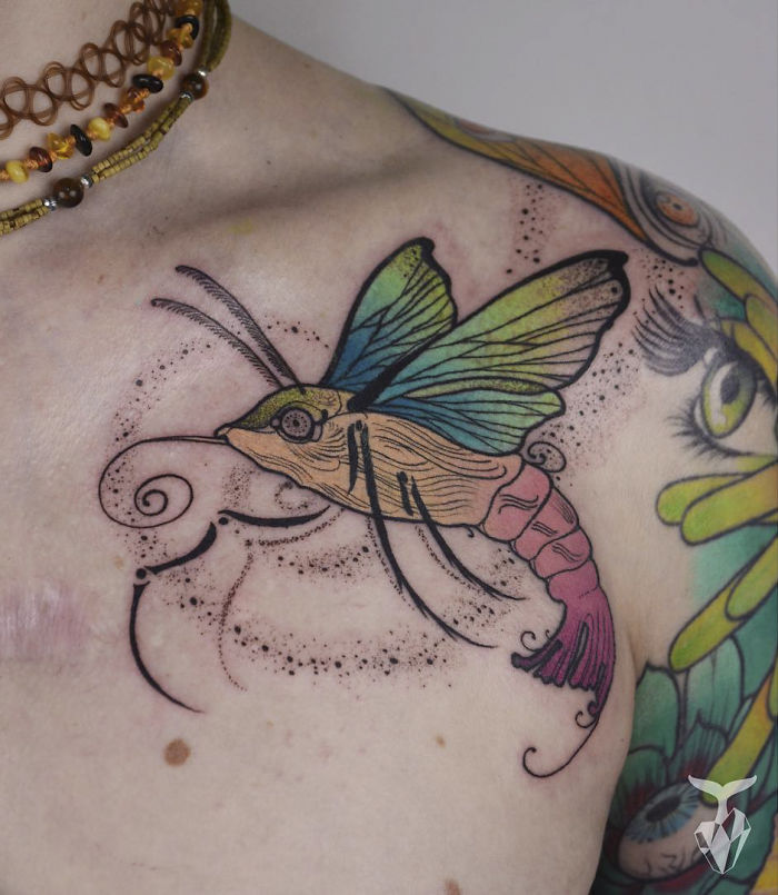 Tattoo featuring a colorful butterfly and floral elements, inspired by nature and Art Nouveau styles.