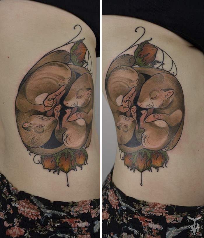 Nature and Art Nouveau inspired tattoo of curled animals on skin.