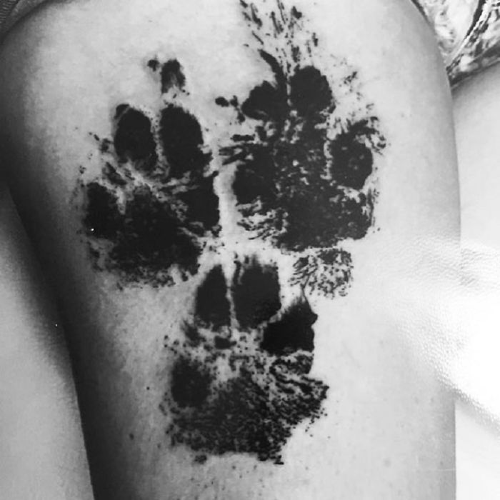 Tattoo of dog paw prints on skin, showcasing pawesome tattoo artistry.