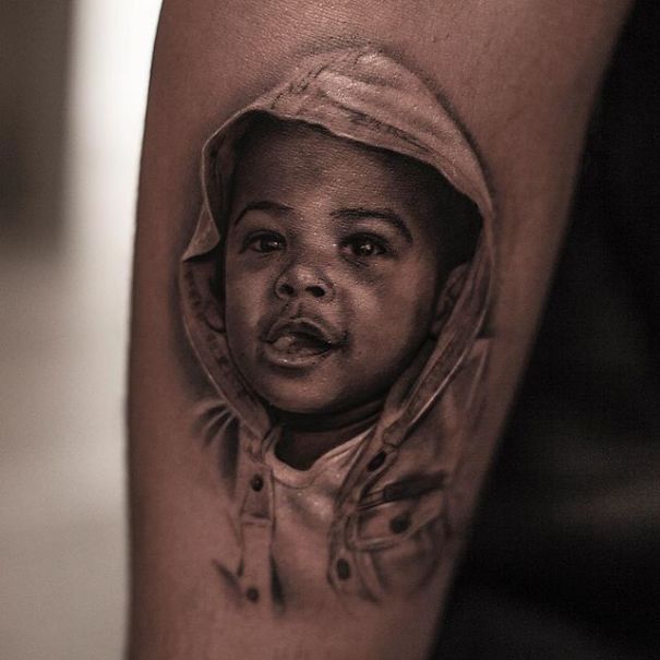 Realistic tattoo of a child in a hoodie, appearing as if printed on the skin by a Belgian tattooist.