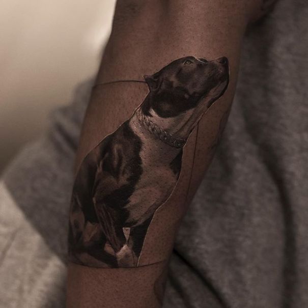Realistic tattoo of a dog on an arm, showcasing detailed artwork by a Belgian tattooist.