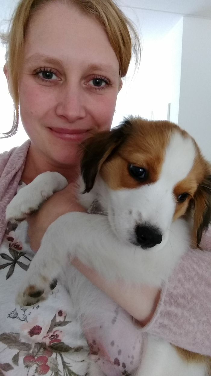 Woman smiling while holding a puppy, illustrating depression symptoms have no face.