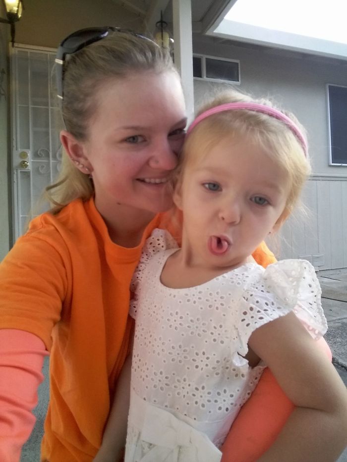 Smiling woman with child in white dress, showing how depression symptoms have no face.
