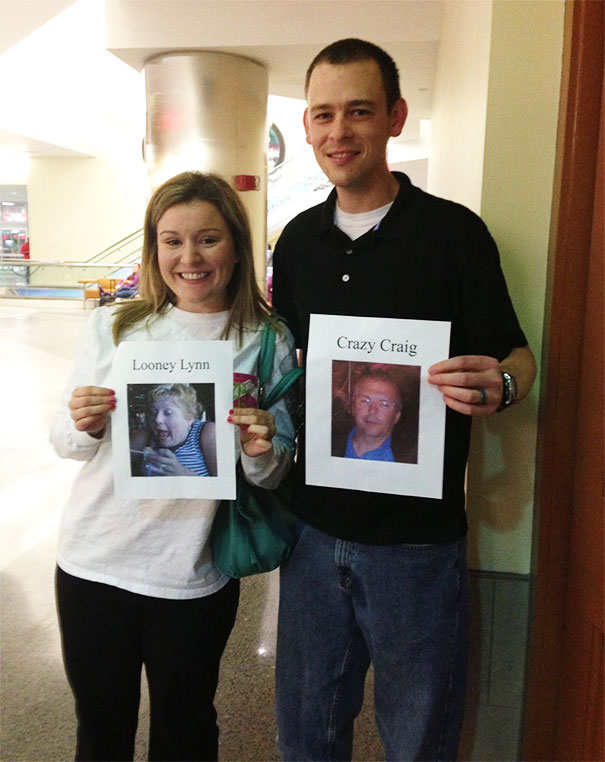 Couple holding funny airport pickup signs with names "Looney Lynn" and "Crazy Craig" at arrivals area.