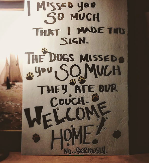 Funny airport pickup sign with paw prints, saying dogs missed you and ate the couch. Welcome home!