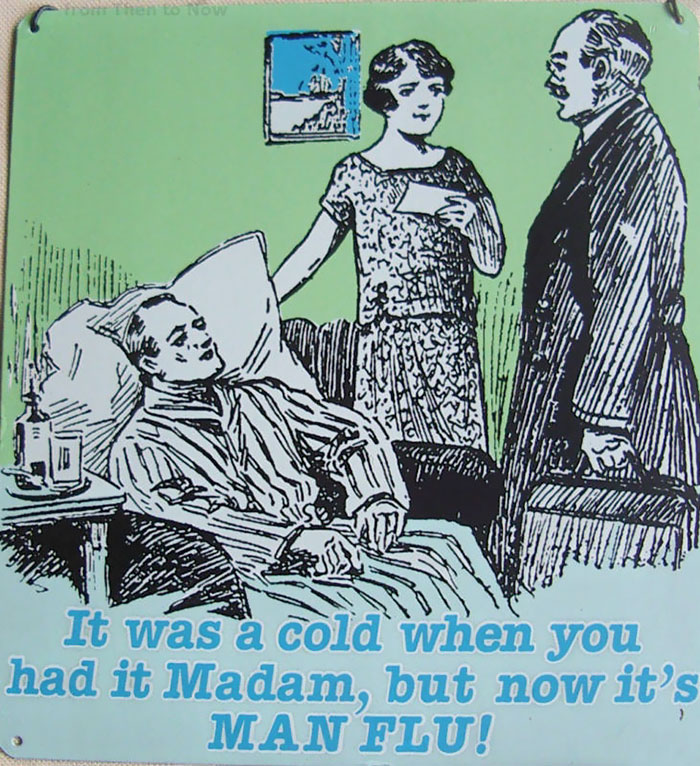Cartoon of a husband in bed with a cold, jokingly labeled as "man flu," with a concerned woman and a doctor standing by.