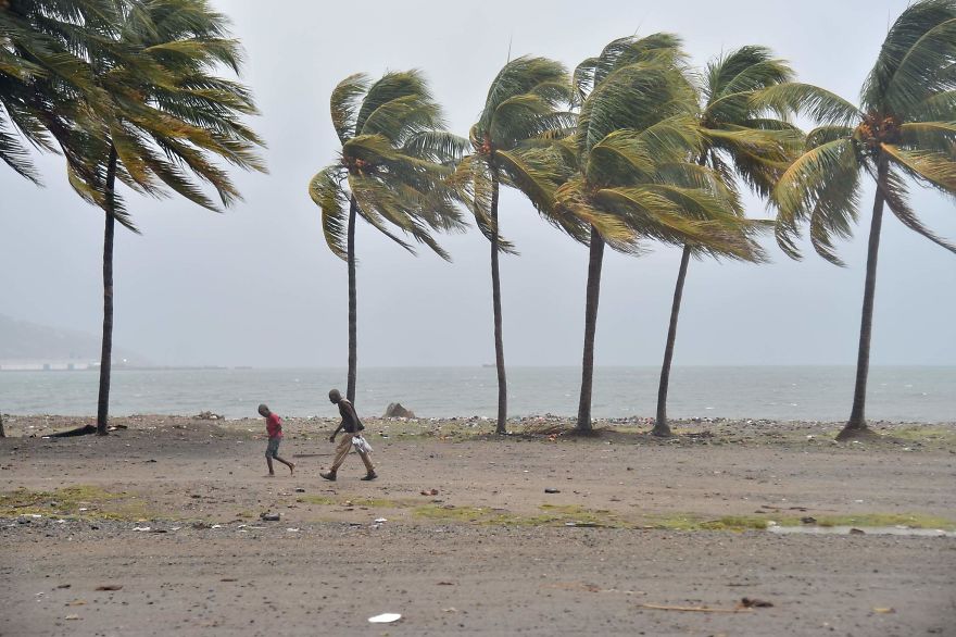 Haitian People Walk Through The Wind And Rain On A Beach, In Cap-haitien As Hurricane Irma Approaches