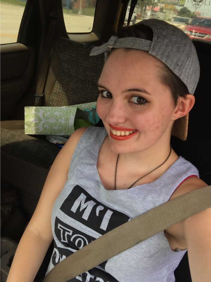 Person smiling in a car, wearing a gray cap and tank top, illustrating that depression symptoms have no face.