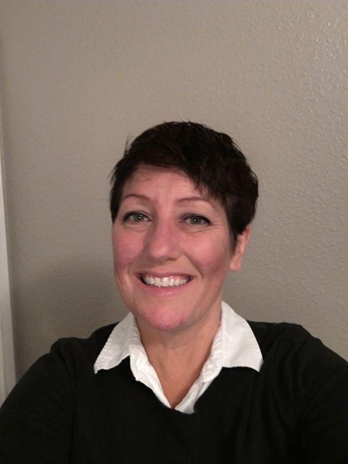 Smiling person highlighting depression symptoms have no face, wearing a white collared shirt and black sweater.