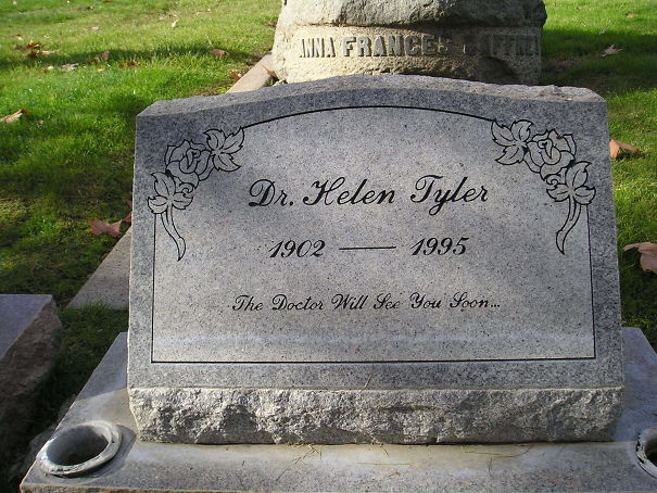 Tombstone of Dr. Helen Tyler with humorous epitaph The Doctor Will See You Soon in a grassy cemetery setting