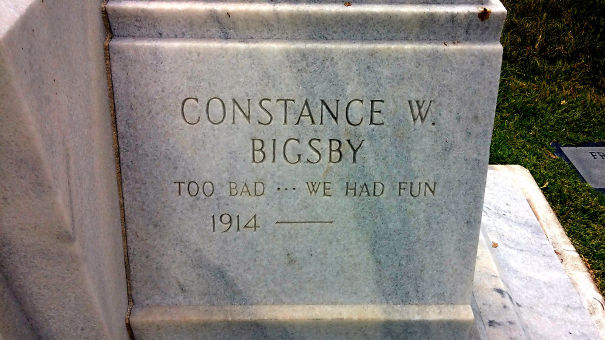 Funny tombstone inscription reading "Too bad ... we had fun" on a gray marble grave marker in a cemetery.