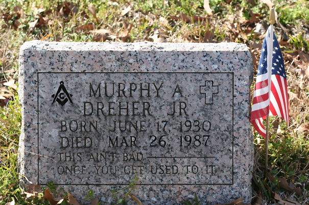Tombstone with a humorous epitaph and an American flag, showing funny tombstones by people with undying humor.