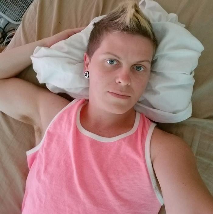 Eric in a pink sleeveless shirt lying down in bed Eric in a pink sleeveless shirt lying down in bed