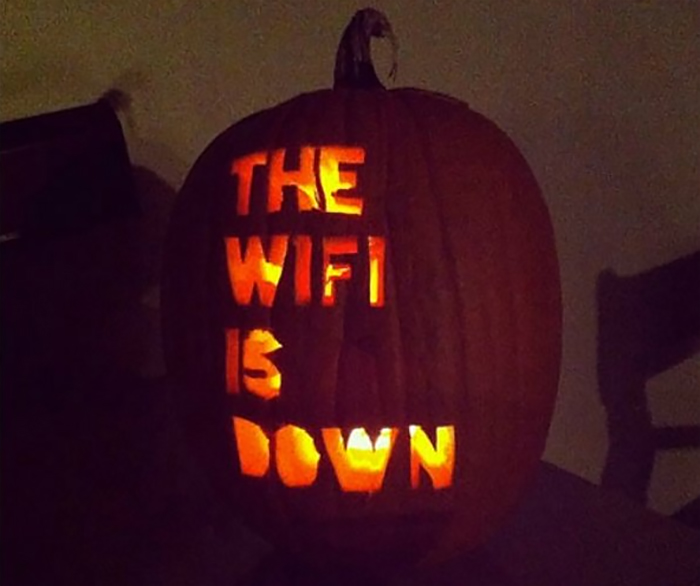 Scary carved pumpkin with "THE WIFI IS DOWN" text glowing from inside.