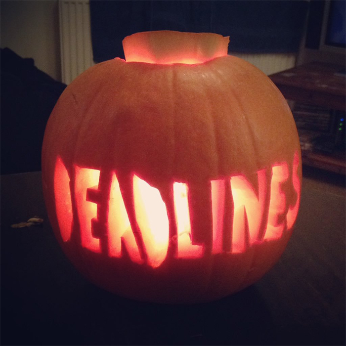 Carved pumpkin with the word "DEADLINES" glowing ominously.