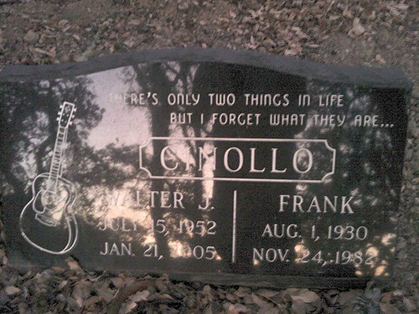 Black tombstone with a humorous epitaph about forgetting life’s two things, featuring a guitar engraving and names Walter and Frank.