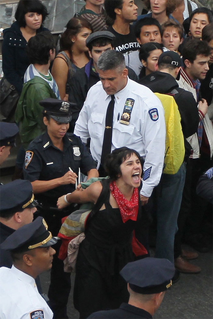 Police Arrest A Demonstrator Affiliated With The Occupy Wall Street Movement After She And Fellow Protesters Attempted To Cross The Brooklyn Bridge On The Motorway. The Arrested Woman Is Seen Screaming Out Her Name To Supporters On The Pedestrian Bridge Above Who Were Recording Names Of Those Arrested. This Portion Of The Bridge Is Not Intended For Pedestrians And As The Marchers Attempted To Cross, They Were Stopped Midway By Police. Hundreds Of Protesters Were Arrested, New York City, 1 October 2011 