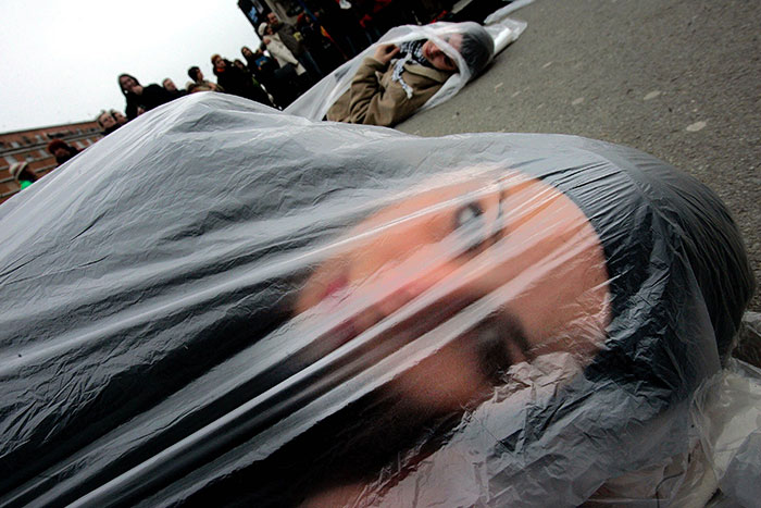 A Member Of The “Women In Black”, An International Peace Network, Lays On The Ground Wrapped In A Plastic Bag, As A Sign Of Protest In Downtown Novi Sad, Serbia, 10 December 2005