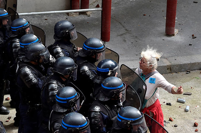 A Woman Stands In Front Of Police Officers As They Block Access To A Street During A Protest Against Proposed Labour Reforms In Paris, 14 June 2016