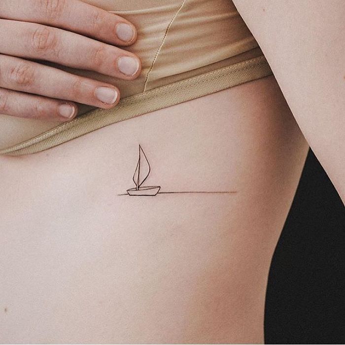 Minimalist sailboat travel tattoo on a person's rib.