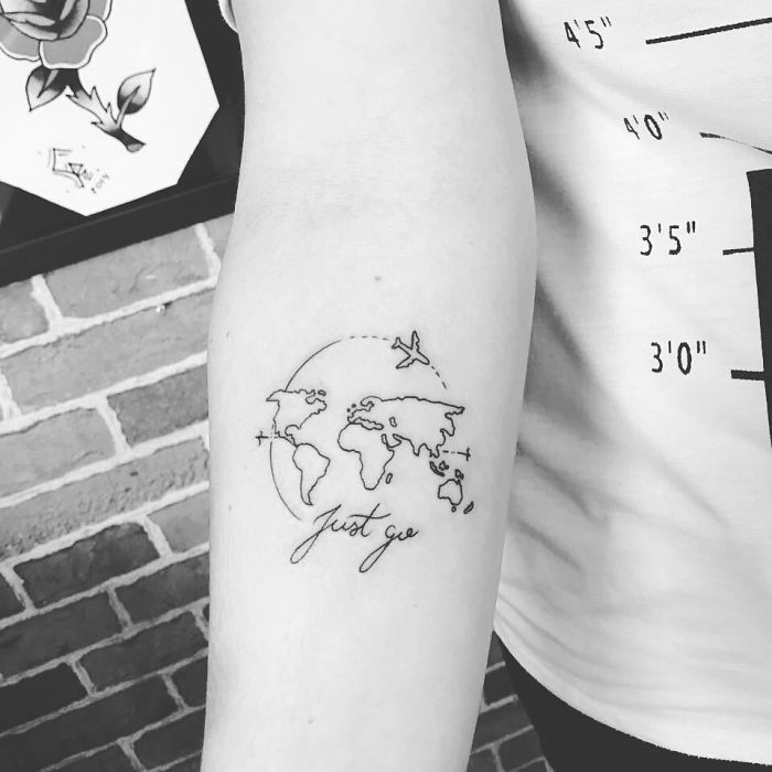 Travel tattoo of a world map with an airplane and "just go" script on an arm, inspiring wanderlust.