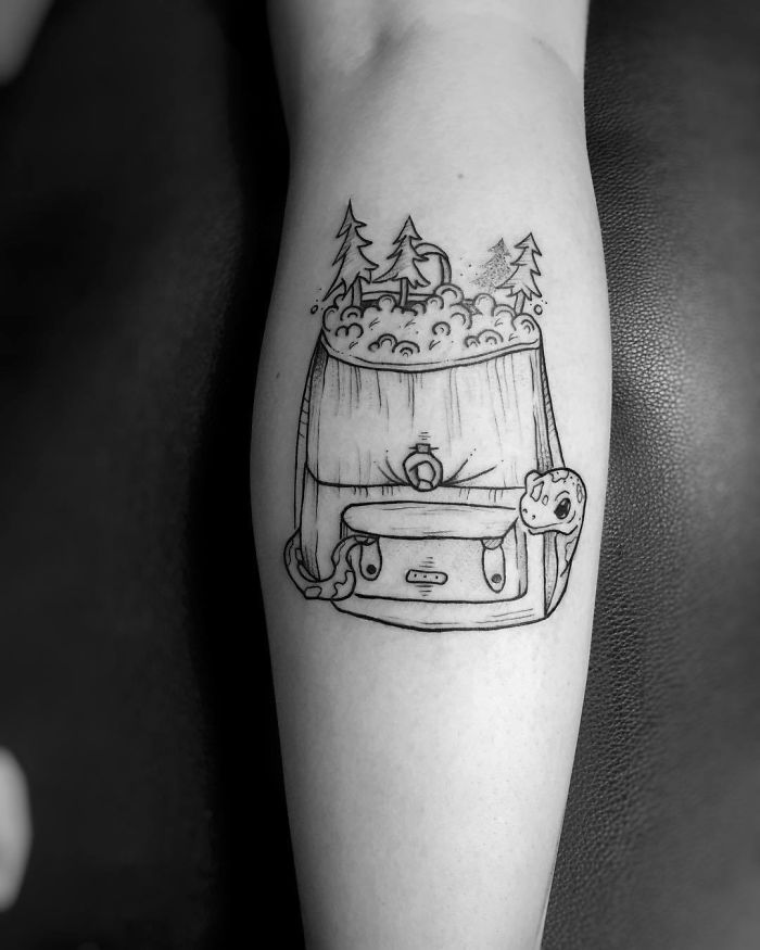 Travel tattoo featuring a backpack with trees and a tent, symbolizing adventure and wanderlust.