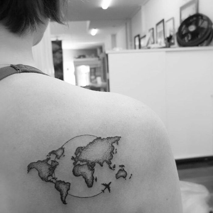World map tattoo on shoulder, symbolizing travel and adventure.