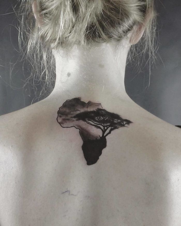 Back tattoo of Africa with a tree, featuring travel-inspired design elements.