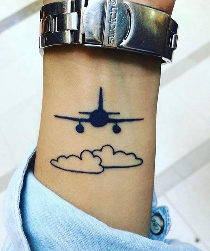 Travel tattoo featuring an airplane flying over clouds, symbolizing wanderlust and the desire to explore the world.