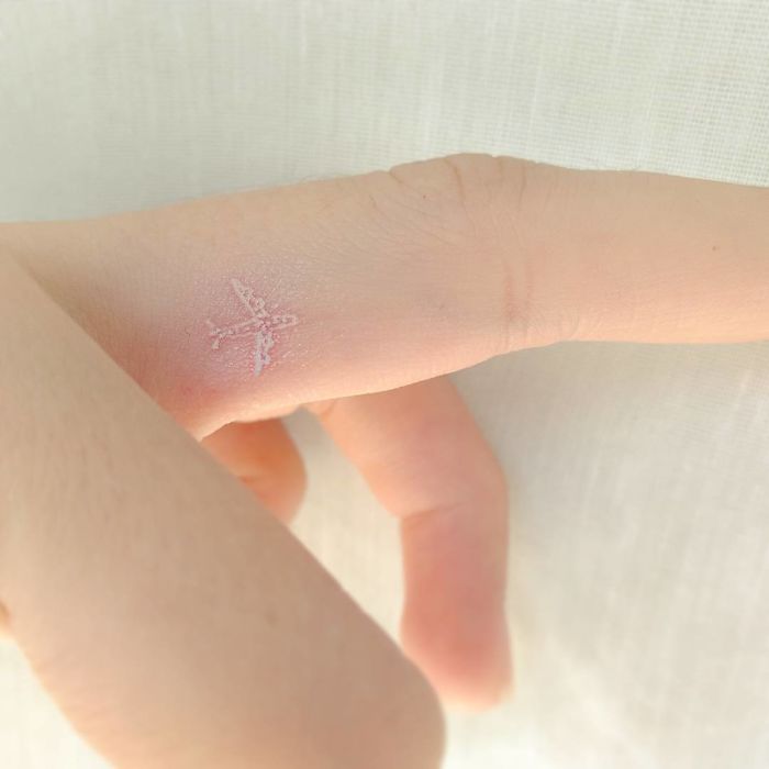 Minimalist airplane travel tattoo on finger, inspiring wanderlust and exploration.